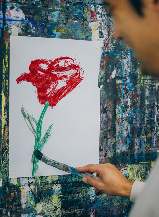 Patient gestaltet lebhaftes Blumengemälde in der Kunsttherapie