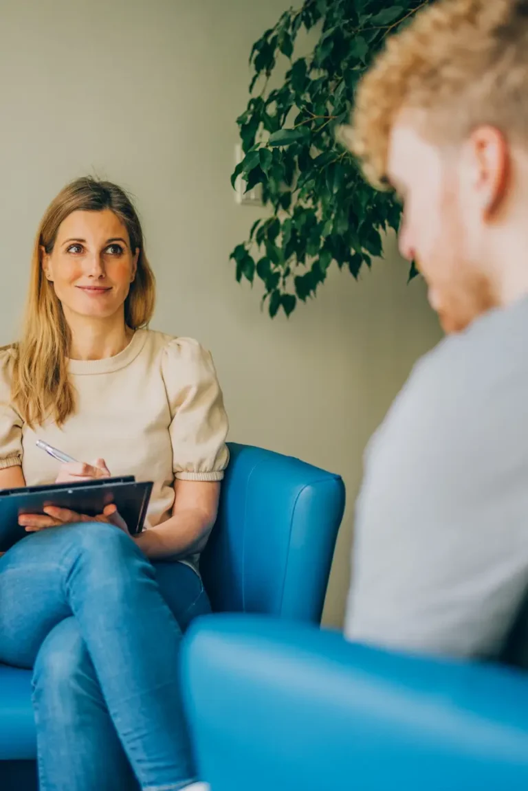 Lächelnde weibliche Therapeutin in einer Sitzung mit einem männlichen Patienten